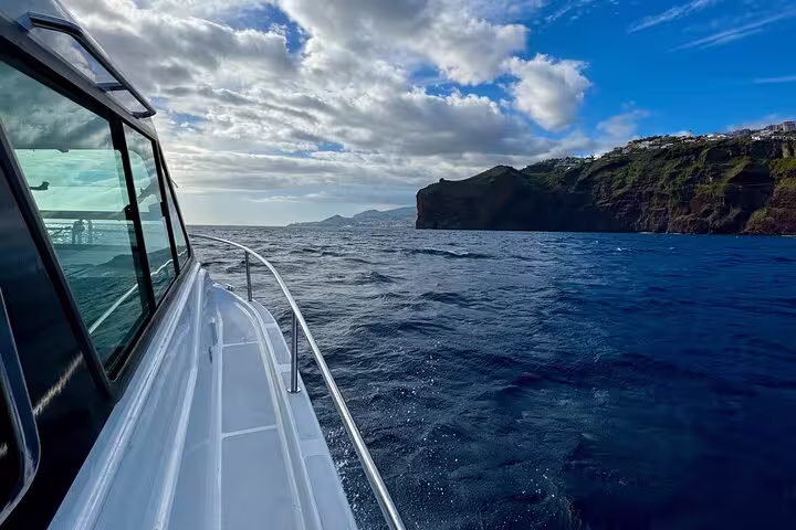 Private yacht navigates along rugged coastline, offering a scenic adventure escape.