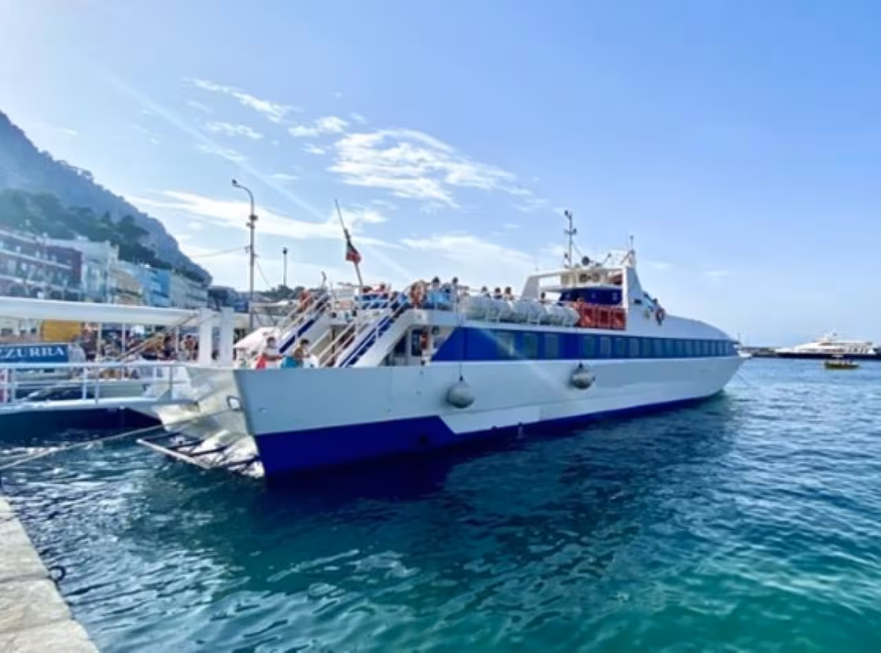 Boat at Procida harbor before island cruise, ideal for hotel pick-up tour and scenic sea ride in Italy