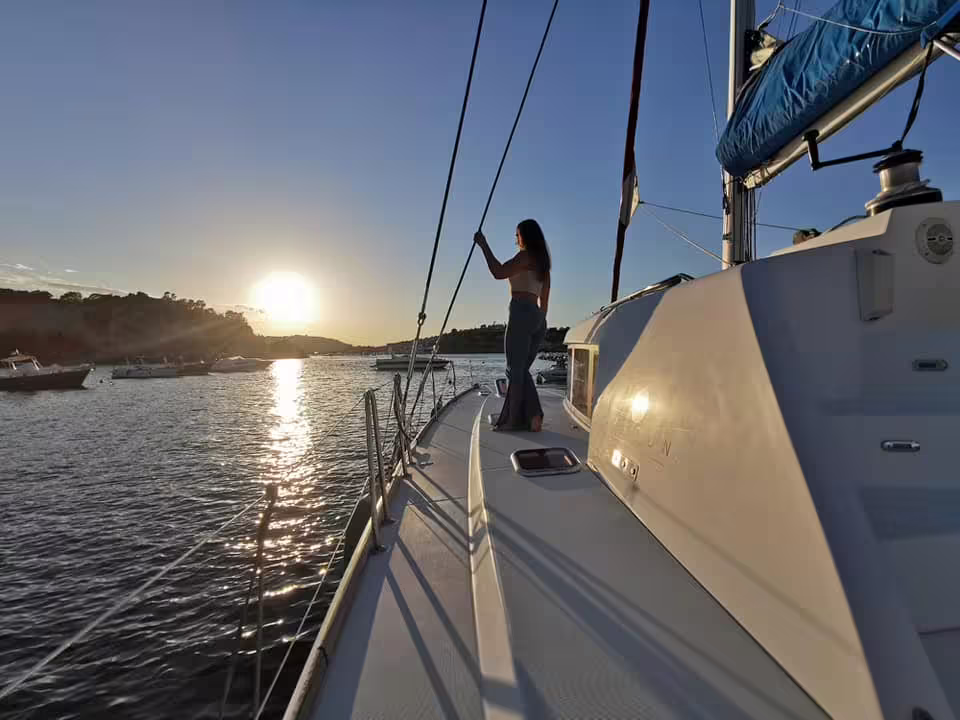 Traveler enjoying golden hour views on the deck during a Procida by catamaran sunset cruise in the Bay of Naples