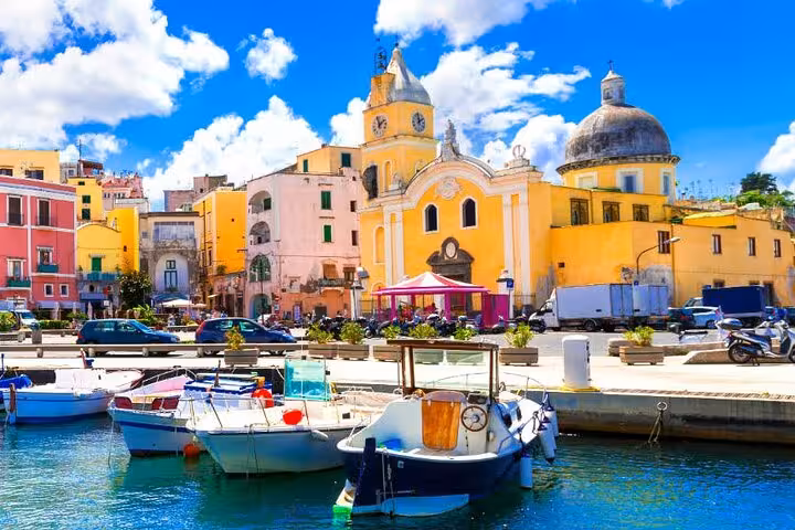 Colorful fishing boats docked at the vibrant harbor of Procida, a highlight of the Ischia and Procida boat tour.