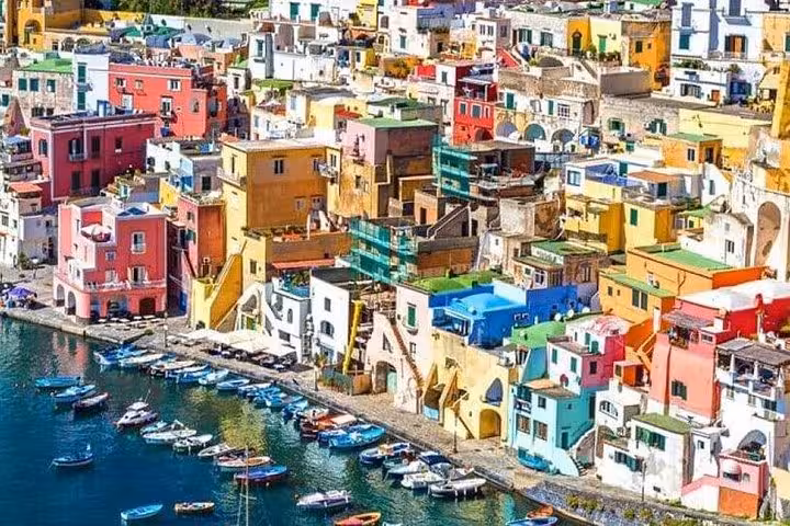 Explore Procida's enchanting harbor with its colorful Mediterranean houses and moored boats offering a picturesque view.