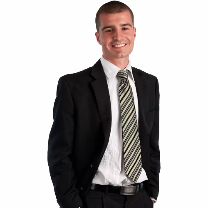 Smiling professional chauffeur in a sleek black suit, representing premium executive car hire and private chauffeur services.