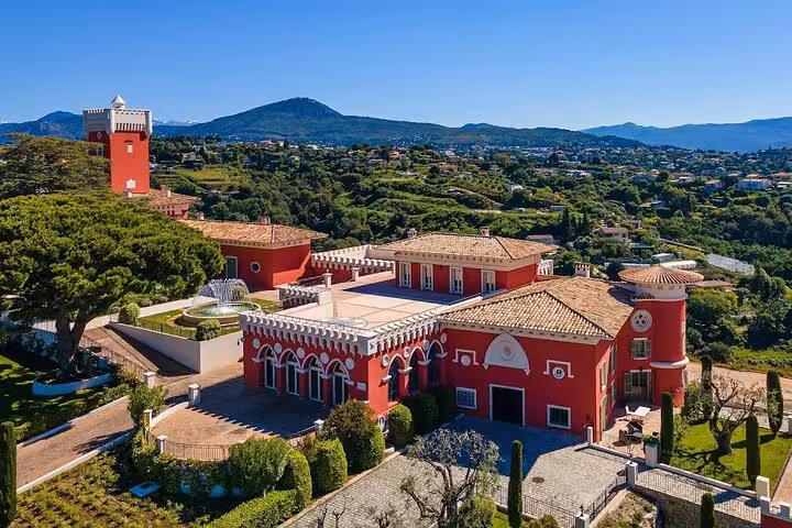 Admire a stunning Provencal chateau surrounded by lush greenery and rolling hills.