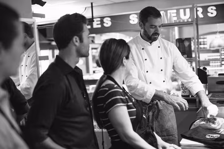 Chef demonstrates Provençal cooking techniques during an Avignon cooking workshop with small group guests