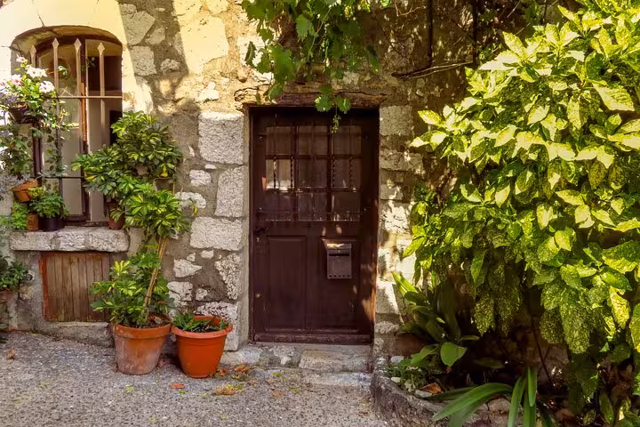 Charming countryside stone house entrance with lush greenery, a picturesque stop on a Provencal private tour.