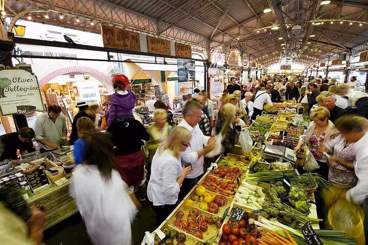 Bustling Provencal market with vibrant stalls of fresh produce, showcasing authentic local culture on a full-day tour.