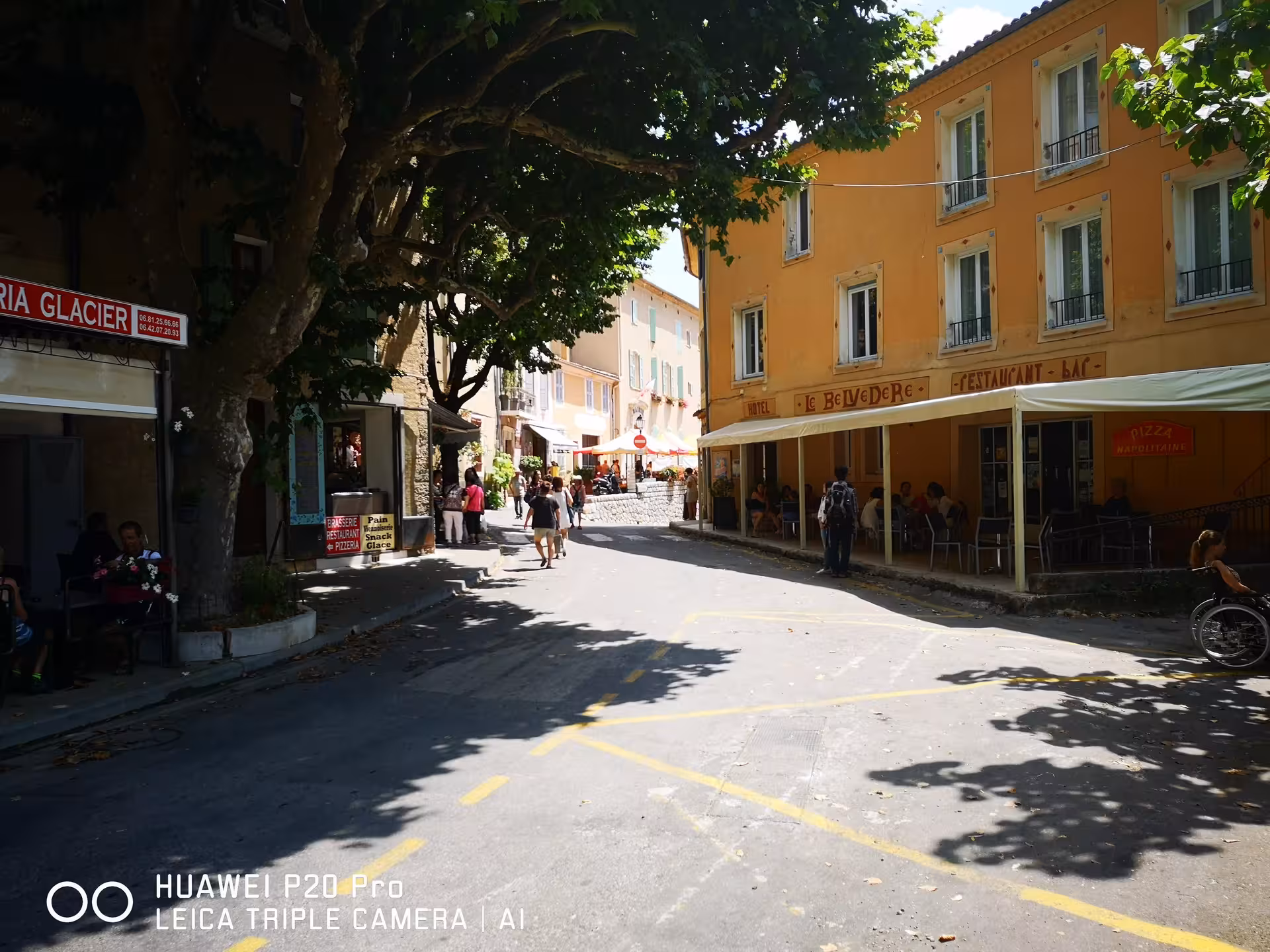 Shaded Provençal street with cafés and pastel buildings, charming village stop on a Lavender Private Day Trip