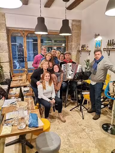 Tour group enjoying live accordion music at a cozy Provence bistro on the 11-day Christian heritage tour
