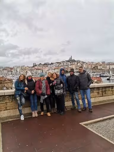 Pilgrims on Provence Christian heritage tour at Marseille viewpoint, with Old Port and basilica skyline