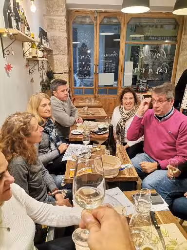 Tour guests enjoying Provençal wine tasting in a rustic bistro during the 11-day Christian heritage tour