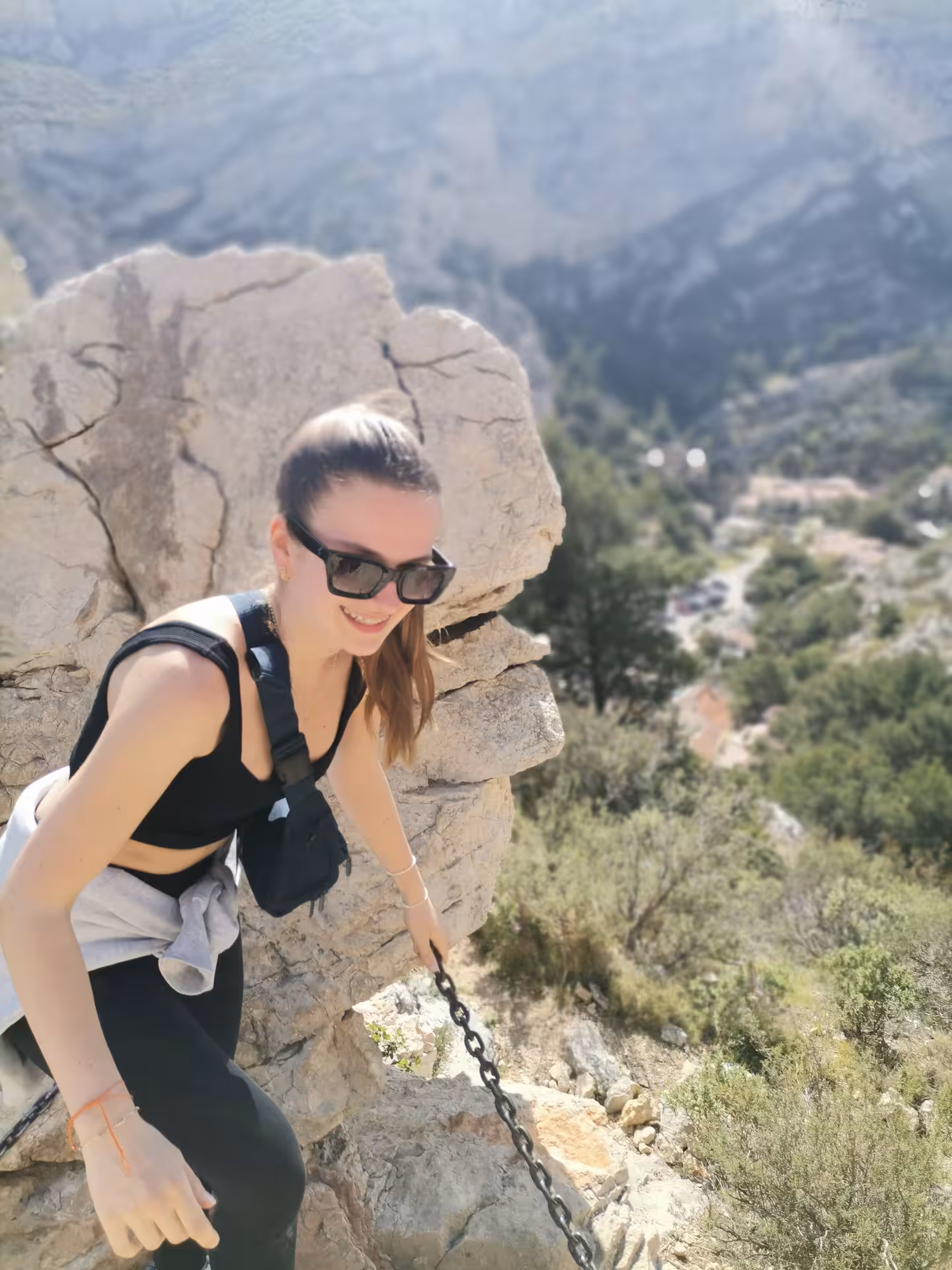 Hiker climbing a rocky Calanques path with chain handrail, enjoying scenic Provence hiking views near Marseille
