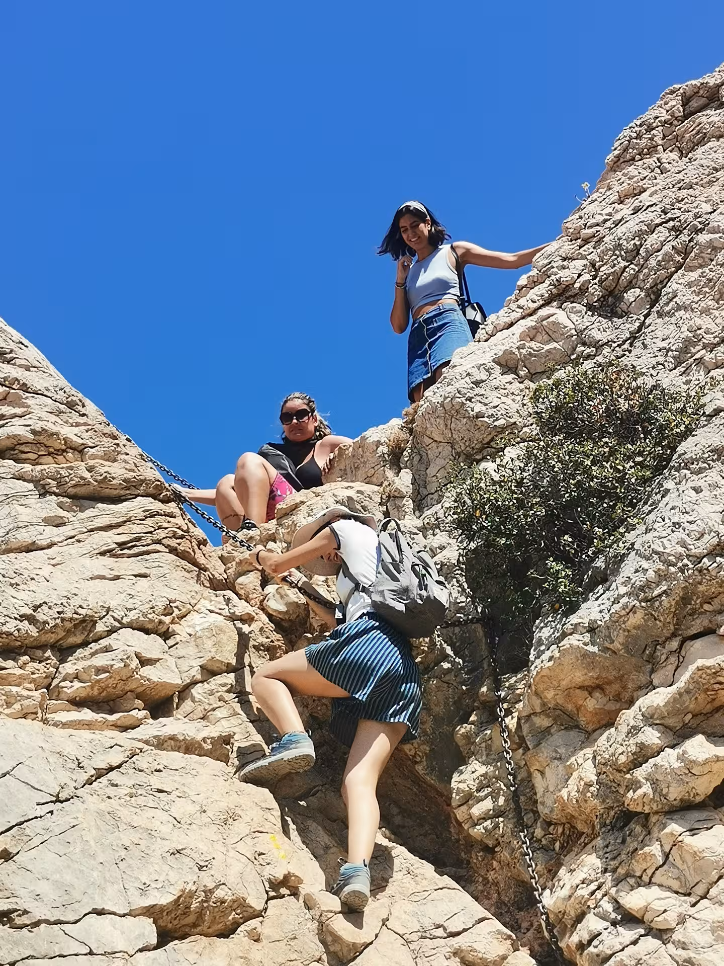 Hikers use a chain-assisted scramble on limestone cliffs in the Calanques, part of an 11-day Provence hiking trip
