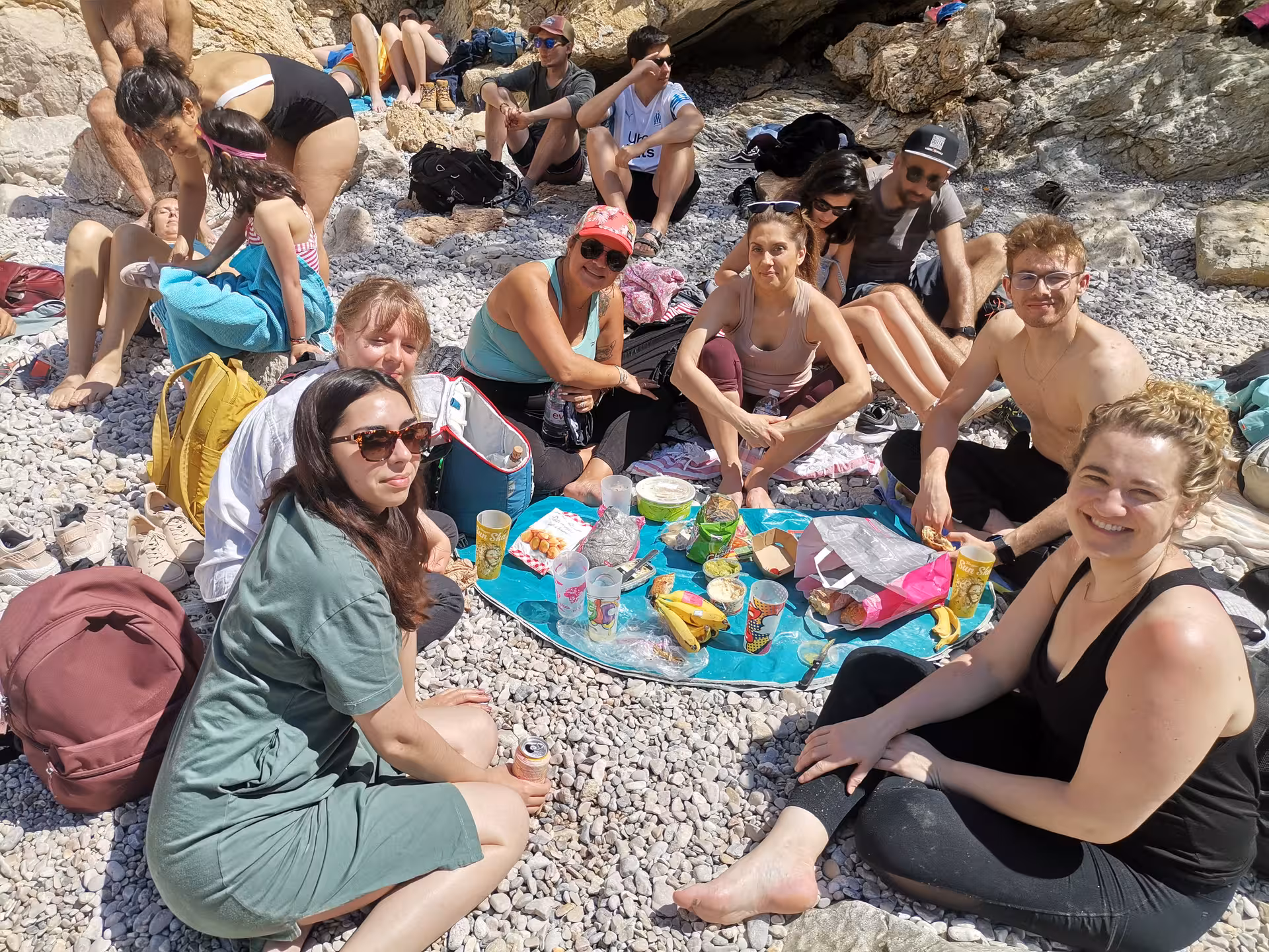 Hikers enjoy a picnic break on a rocky beach during an 11-day Provence hiking and culture getaway in France