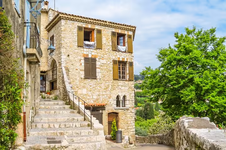 Stone medieval village house with wooden shutters and stone staircase in Provence, France