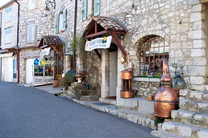 Stone buildings with copper distillery stills outside a perfume shop in a Provence village