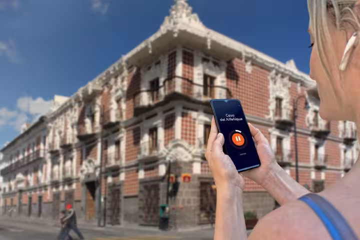 Tourist using audio guide app on smartphone in front of Casa del Alfeñique in Puebla, Mexico