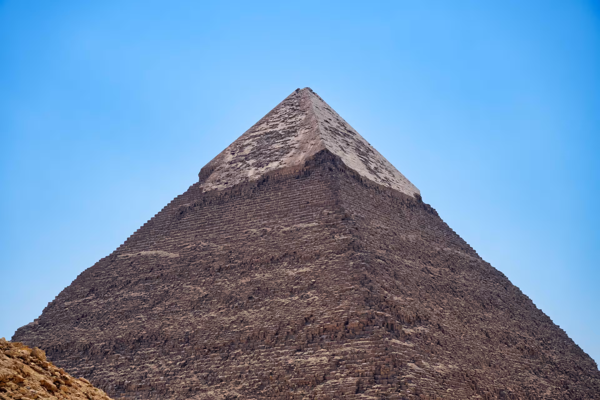 Close-up view of the Pyramid of Khafre at Giza showing limestone blocks and remaining casing stones against blue sky