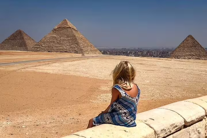 Traveler overlooking the Pyramids of Giza plateau near Cairo on a day tour by plane from Sharm El Sheikh, Egypt