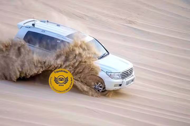 Experience thrilling Qatar dune bashing with a 4x4 SUV kicking up sand in the expansive desert landscape.