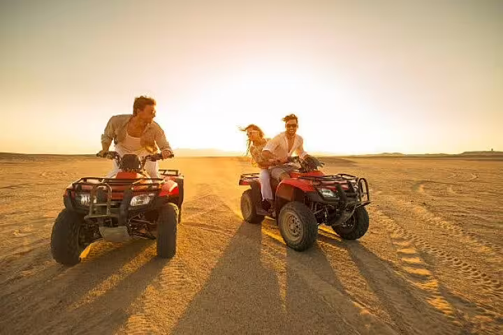Couple and friend on quad bikes in the Sinai desert at golden hour during a private ATV tour from Sharm El Sheikh