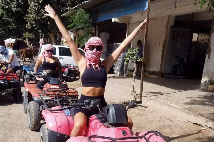 Tourists on quad bikes in Cairo desert safari, wearing scarves for Camel Ride, lunch and shopping tour