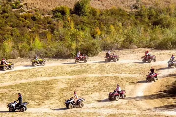 Adventurous group rides quad bikes across scenic trails near Kusadasi Port, exploring beautiful landscapes and nature.