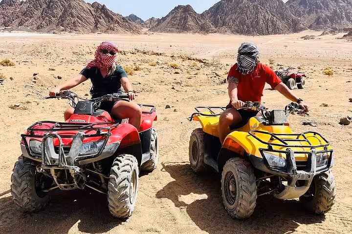 Two riders on quad bikes in Sinai desert near Sharm El Sheikh, part of shared safari and sea activities tour