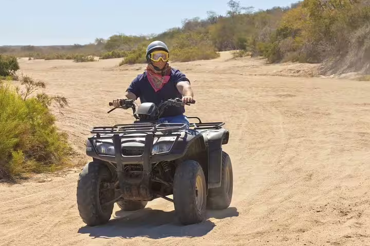 Adventure seeker enjoying quad biking on sandy trails near Kusadasi Port, ideal for cruise guests seeking excitement.