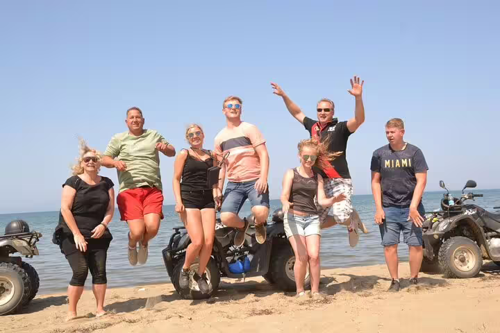 Group of tourists celebrating on the beach after an exciting quad biking tour from Kusadasi Port.