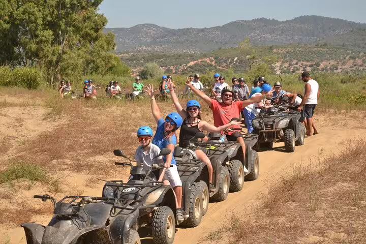 Happy cruise guests on a guided quad riding tour exploring beautiful landscapes near Kusadasi.