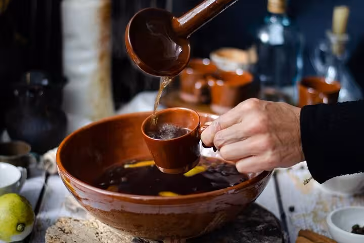 Traditional Queimada ritual with clay cups and ladle at Santiago de Compostela tasting experience.