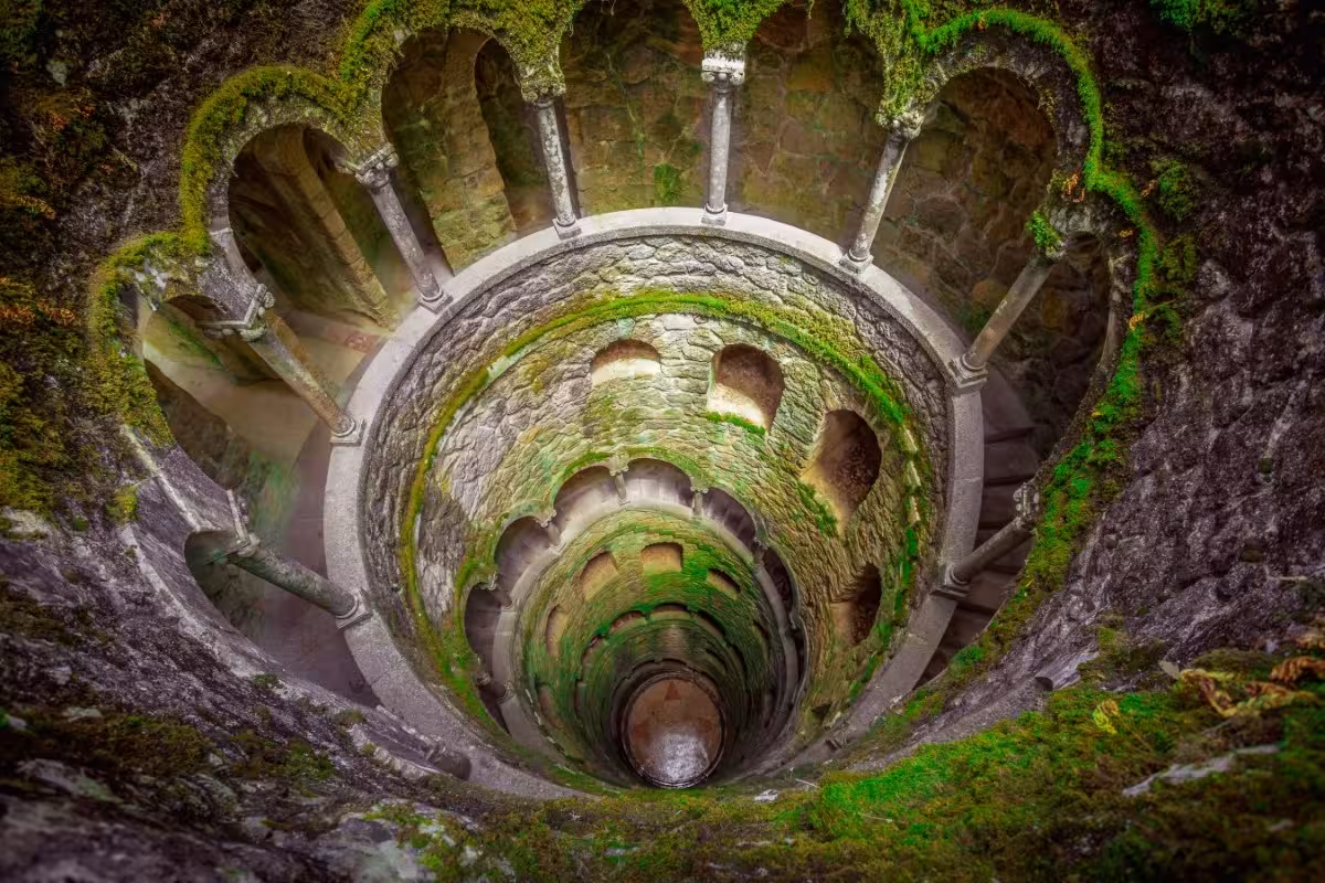 Quinta da Regaleira Initiation Well in Sintra, mossy spiral staircase on a Sintra day trip tour