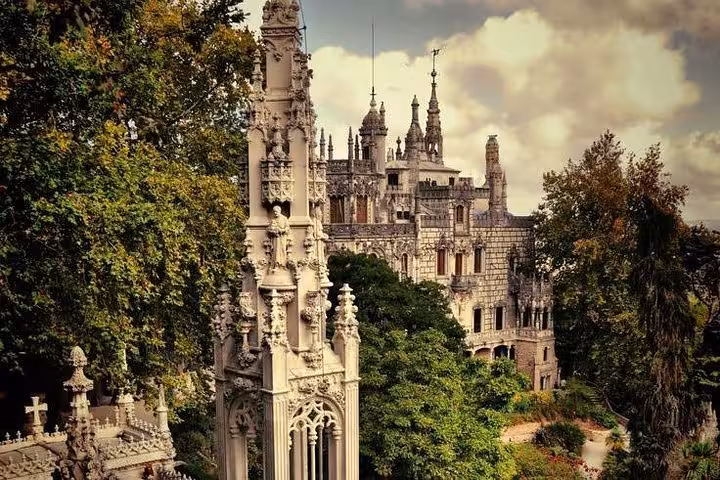 Gothic towers of Quinta da Regaleira in Sintra framed by lush gardens on a self-drive monuments and coast tour