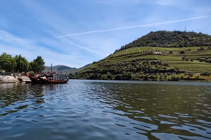 Rabelo boat on the Douro River by terraced vineyards in Pinhão, Portugal, scenic viewpoint on Visit Pinhão