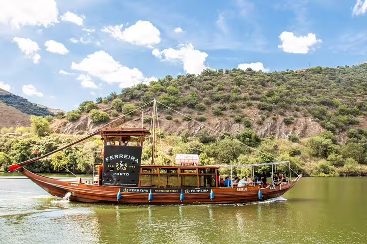 Traditional rabelo boat sailing on the Douro River during a scenic Douro Valley tour from Porto.