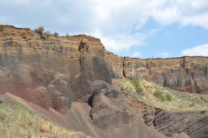 Volcanic rock cliffs and layered geological formations at Racos quarry near Brasov, Romania