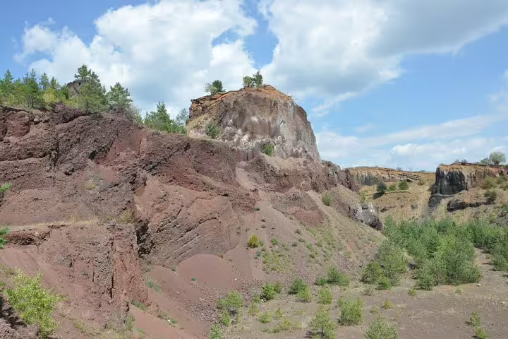 Red volcanic rock formations and cliffs at Racos quarry near Brasov, Romania