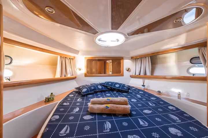 Luxurious cabin interior of Raffaelli Shamal 40 yacht with a cozy double bed, ideal for private tours from Sorrento to Capri.
