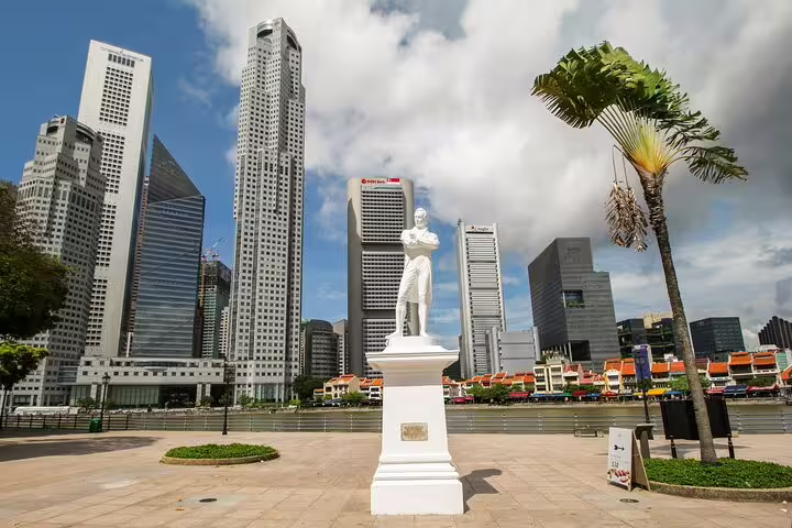 Sir Stamford Raffles statue on Singapore Riverfront with downtown skyscrapers in background