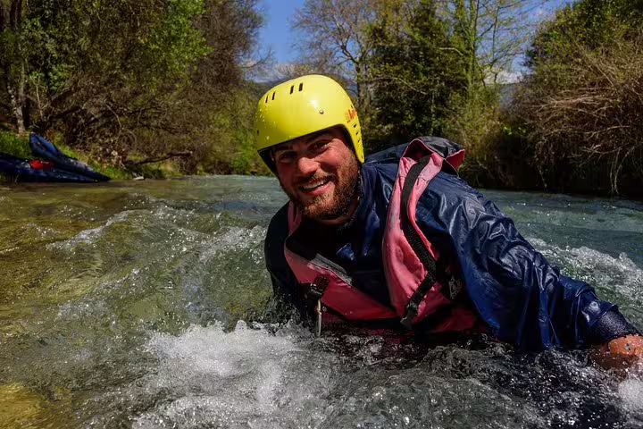 Smiling rafter floating in clear rapids on the Lousios–Alfeios river rafting tour in Peloponnese Greece