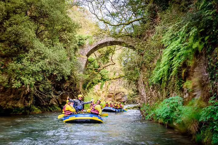 Rafting on Lousios River under a stone arch bridge in lush gorge, Alfeios adventure tour in Peloponnese