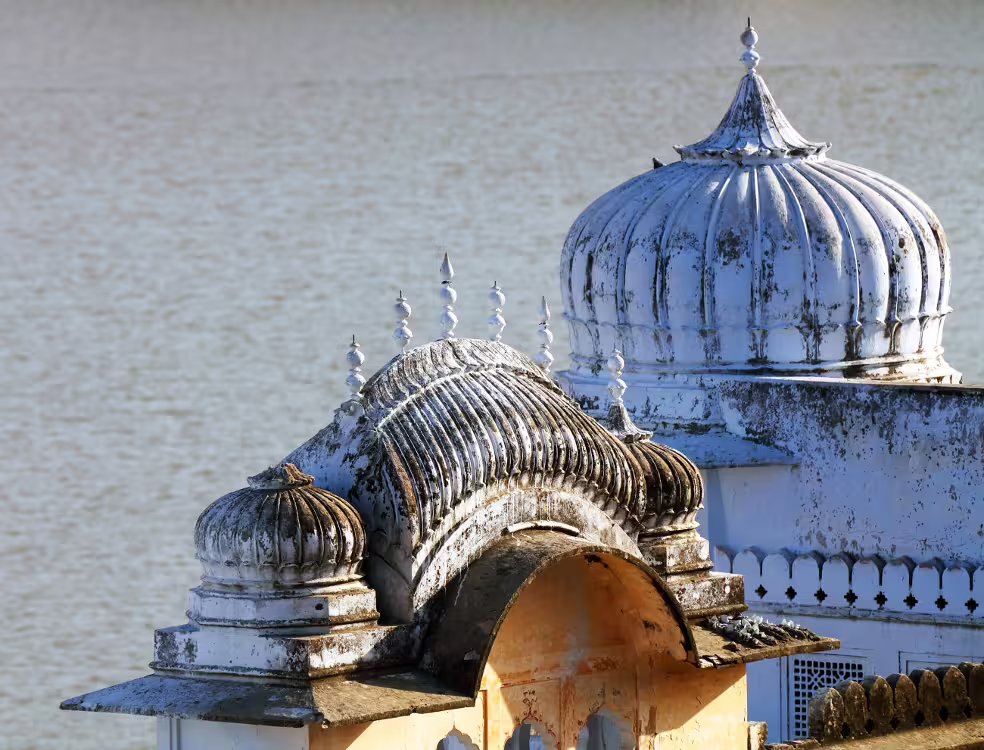 Close-up of ornate domes by Pichola Lake, showcasing traditional Rajasthani architecture in Udaipur, Rajasthan.