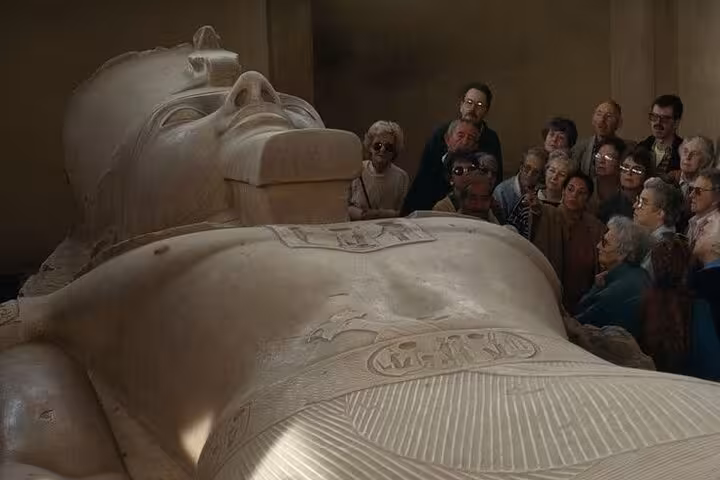 Tour group beside the giant Ramses II statue at Memphis Museum, part of the Giza Pyramids Saqqara day tour