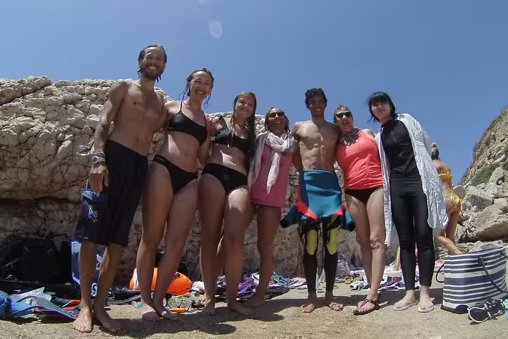 Group photo at a rocky cove during the Rando-Palmée island getaway, snorkeling tour break under blue sky