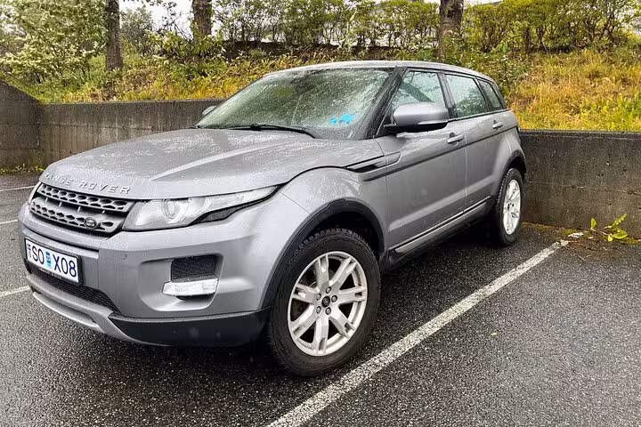 Gray Range Rover Evoque SUV parked in lot, available for private airport transfer service