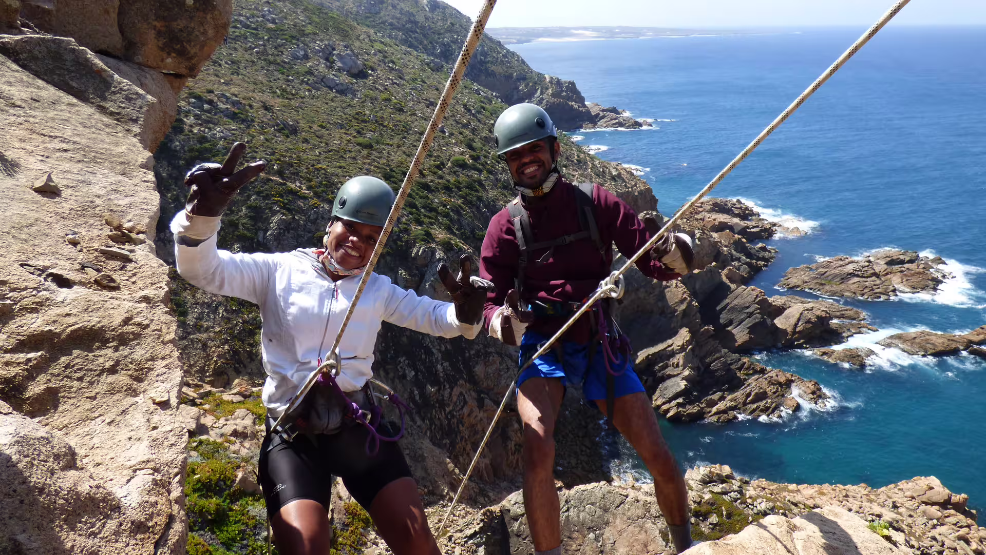 Adventurers enjoying a thrilling rappelling experience on Sintra's stunning coastal cliffs, offering breathtaking ocean views.