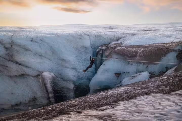 Adventurer rappels across a deep glacial crevasse on an exciting glacier adventure tour from Glacier Lagoon Iceland
