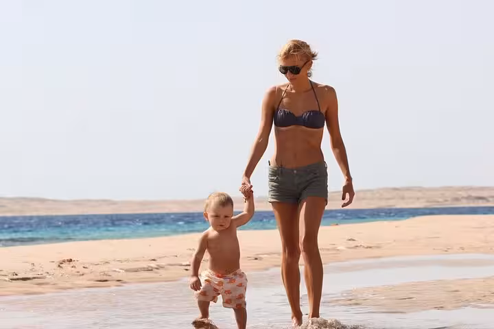 Mother and child walking at Red Sea shoreline on Ras Mohamed half-day tour from Sharm El-Sheikh