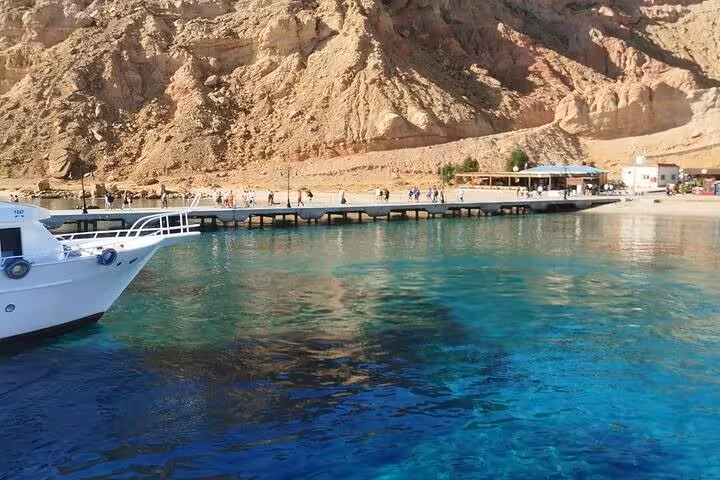Boat moored by Ras Mohammed jetty with crystal-clear Red Sea water, start of White Island snorkeling trip