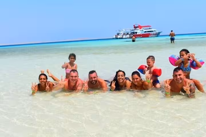 Group relaxing in shallow White Island sandbar, Ras Mohammed snorkeling trip from Sharm El Sheikh